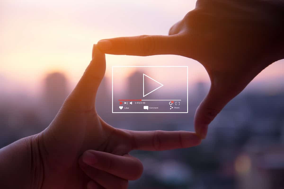 concept video en ligne entre deux mains et sur un fond flou de coucher de soleil